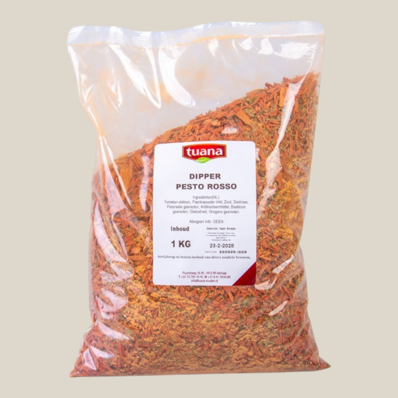 TuanaShop BV Dipper Pesto Rosso kruidenmix in een doorzichtige zak van 1 kg met rode en groene mediterrane kruiden.