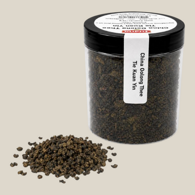 TuanaShop BV China Oolong Thee Tie Kuan Yin in een transparante pot met losse, opgerolde theeblaadjes op witte achtergrond