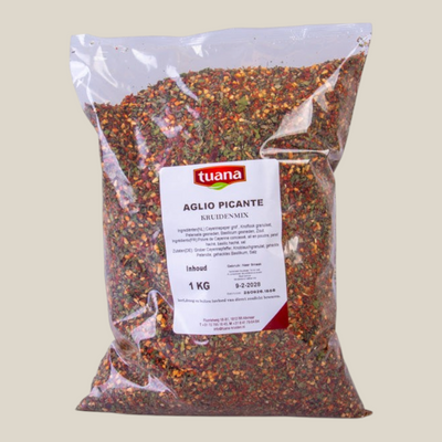 TuanaShop BV Aglio Picante kruidenmix in een transparante 1kg verpakking met gedroogde knoflook, peper en kruiden.