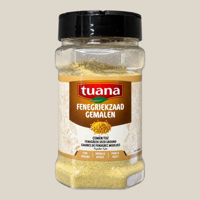TuanaShop BV gemalen fenegriekzaad in een transparante kruidenpot met zwart deksel voor een aromatische smaak.
